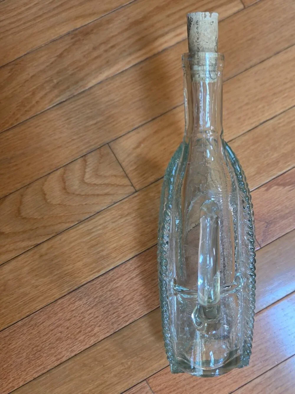 vintage molded clear wine decanter mimics a bottle resting in a basket